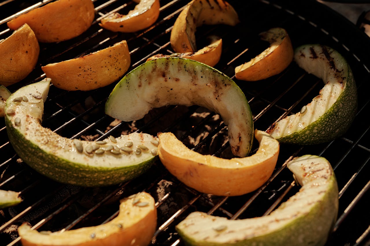 Close-up of sliced cantaloupe and melon on a barbecue grill, perfect for summer cooking.